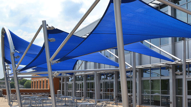 Tension shade sail installation on a commercial property using blue Polyfab shade sail fabric