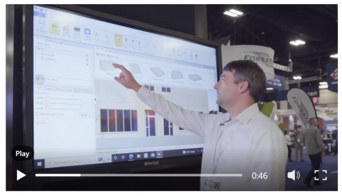 Screenshot from a video: Man pointing at a wide touchscreen displaying various product choices