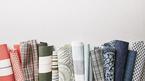 Rolls of assorted fabric in various patterns