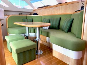 Sailing yacht interior with a green and light beige color-themed sofa and table