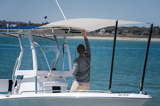 Man finishing installation of Marine Shade Fly while on his boat