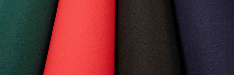 Sunbrella Exceed FR awning fabric rolls in vibrant red, green, blue, and black