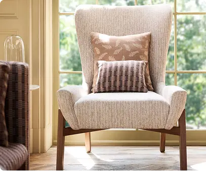 Indoor chair upholstered in white/beige textured fabric.