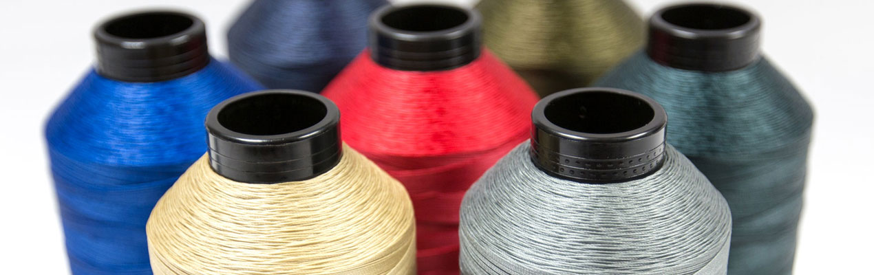 Close-up view of multiple spools of threads in various vibrant colors