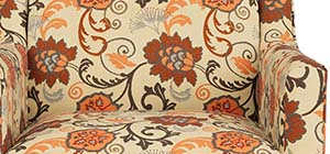 a chair covered in red, orange, and black floral patterns