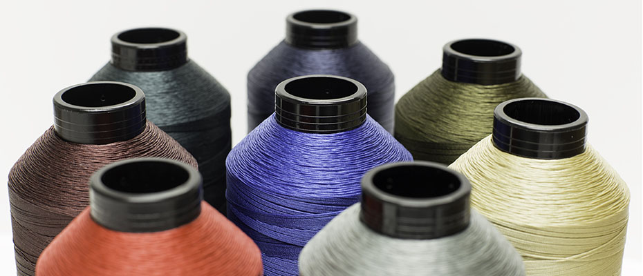 Close-up view of multiple spools of threads in various vibrant colors