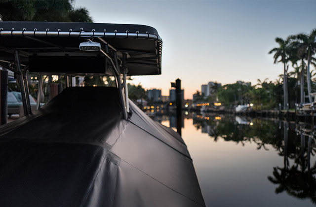 yacht docked in harbor with black boat cover
