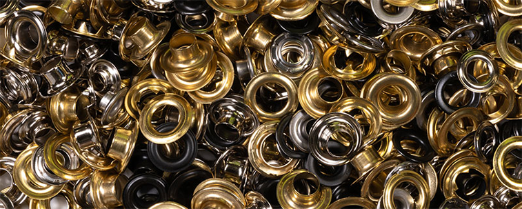 close up view of a pile of different colored metal grommet fasteners for upholstery