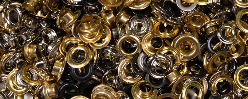 Close up view of a pile of different colored metal grommet fasteners for upholstery
